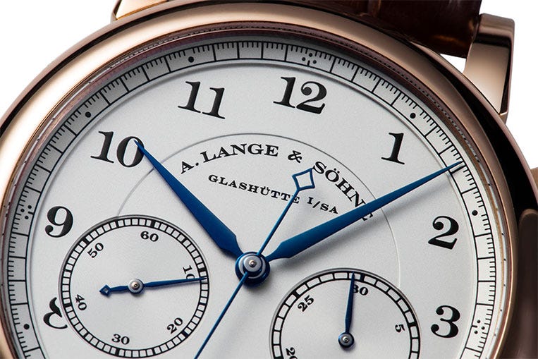 Heat-blued hands tick around the bead-blasted silver dial